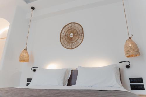 a bedroom with a bed with two lamps and two pillows at Oliving Mykonos Luxury Suites in Klouvas