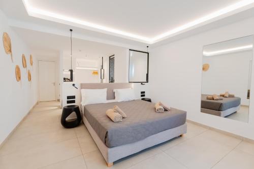 a white bedroom with a large bed and a couch at Oliving Mykonos Luxury Suites in Klouvas