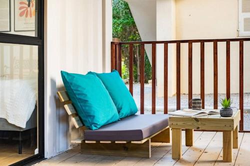 a bench with blue pillows on a porch at the container house in Ra‘ananna