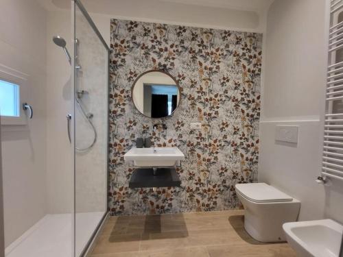 ein Badezimmer mit einem Waschbecken, einem WC und einem Spiegel in der Unterkunft La Casa di Nella in Lastra a Signa