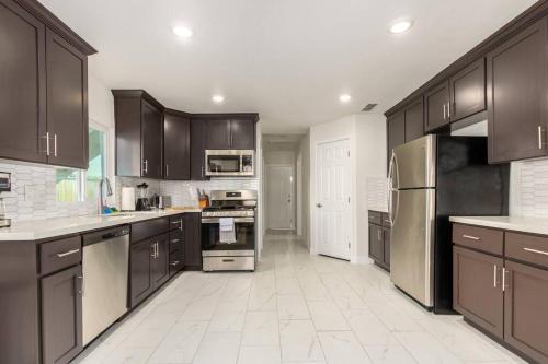 a large kitchen with brown cabinets and appliances at Your Downtown Home With California King Bed Unit A in Phoenix
