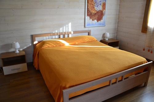 a bedroom with a bed with an orange bedspread at B&B SanteBice in Polignano a Mare