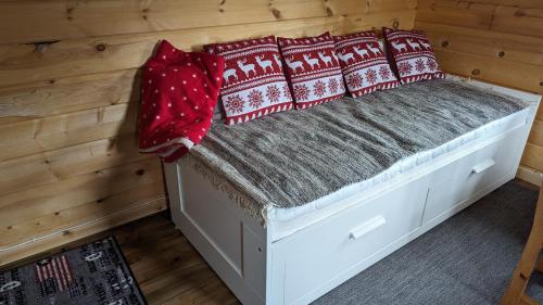 a bed in a cabin with red pillows on it at Lapland Snow Moose in Vittangi Kapell
