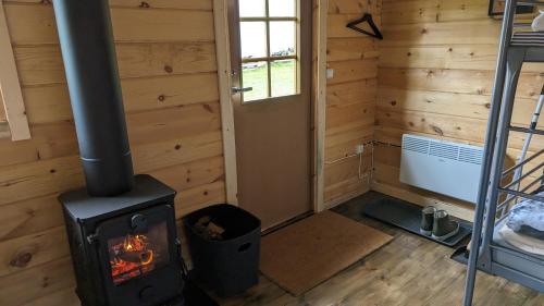 a log cabin with a stove in a room at Lapland Snow Moose in Vittangi Kapell