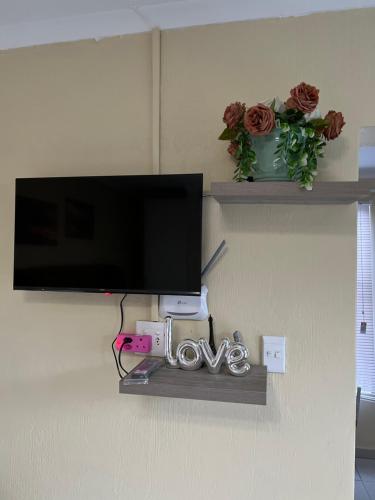 Un televisor de pantalla plana colgado en una pared en MorningMist Boutique Sun, en Centurion