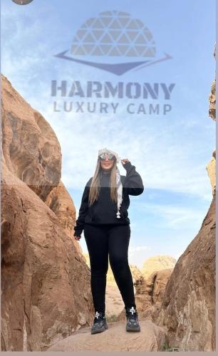 a woman standing on a rock in the desert at Harmony Luxury Camp in Wadi Rum