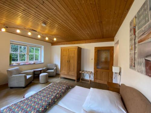 a living room with a bed and a couch at Schumacher's Landhaus - Bücherhotel in Friedeburg