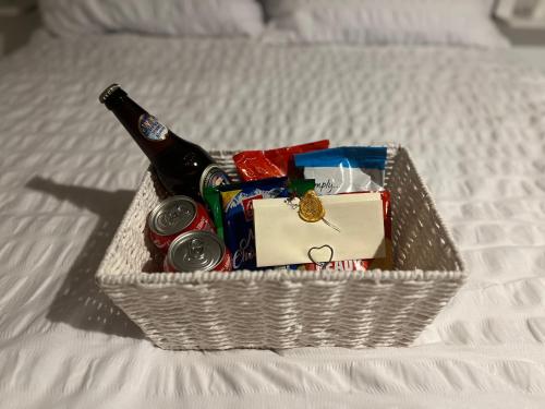 a basket on a bed with a bottle of beer at Hidden Havens in Norwich