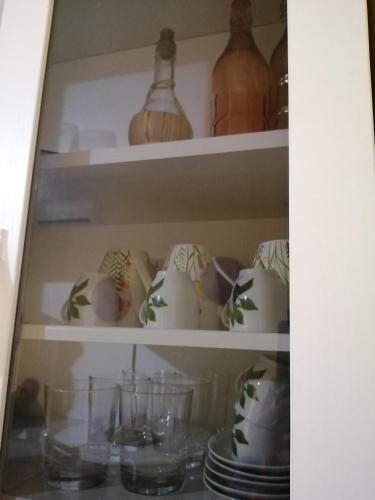 a shelf filled with lots of glass vases and bowls at Karaly - Casa vacanze posto auto/moto in Cagliari
