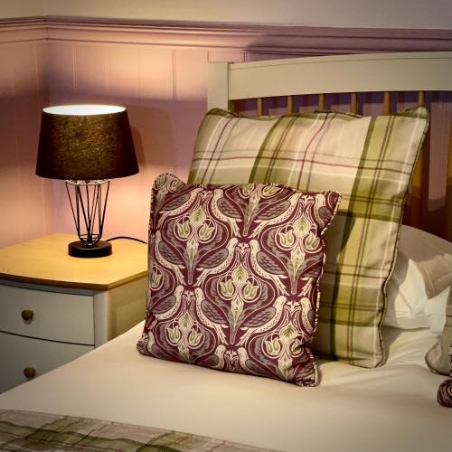 a pillow sitting on a bed next to a lamp at Sibton White Horse Inn in Saxmundham