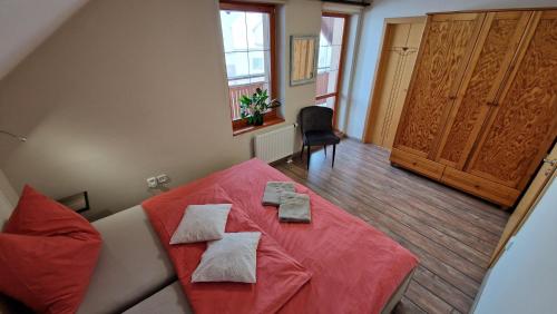 a bedroom with a red bed with towels on it at Rekreační chalupa Pištín in Pištín