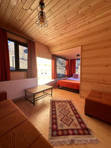 a bedroom with a bed and a couch and a table at Kazbegi Inn Cottages in Stepantsminda