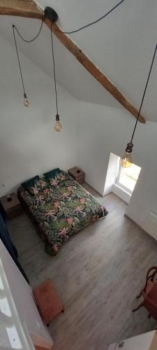 Cette chambre mansardée comprend un lit. dans l'établissement Maison de campagne au calme, à Molac