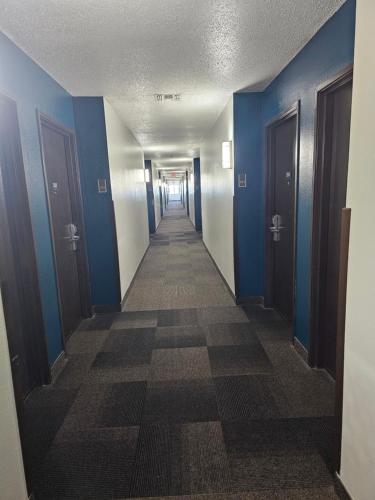 an empty hallway with blue walls and a long corridor at Motel 6 Sinton TX in Sinton