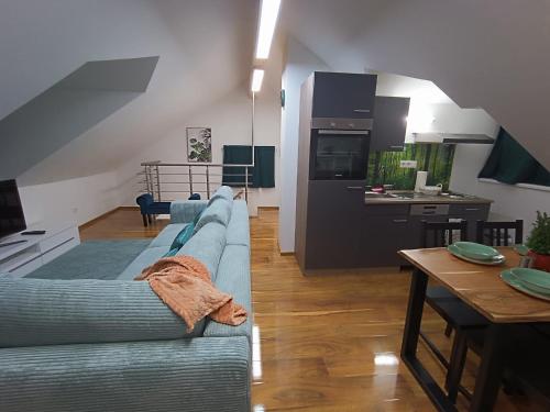 a living room with a blue couch and a kitchen at Cozy Stay Apartments in Salzburg