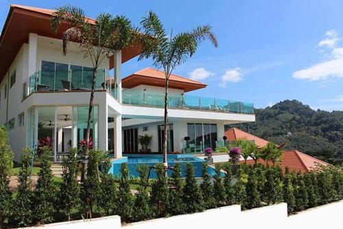 a large house with a swimming pool in front of it at Kamala Heights Villa in Kamala Beach