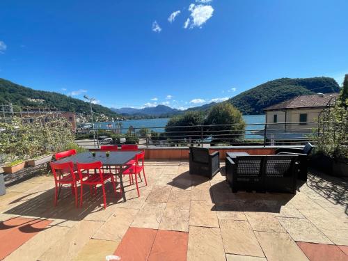 un patio con mesa y sillas y vistas al agua en Reflections At The Lake en Lavena Ponte Tresa