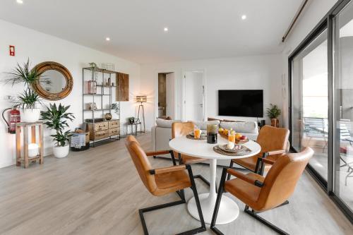 a dining room and living room with a table and chairs at Casa Nascer do Sol in Atouguia da Baleia