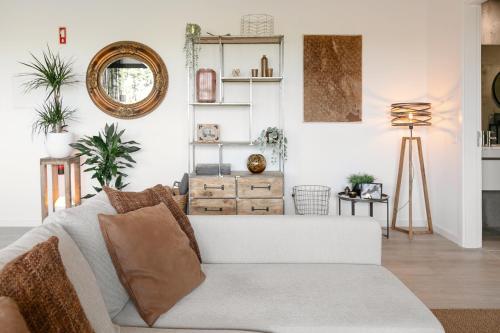 a living room with a couch and a mirror at Casa Nascer do Sol in Atouguia da Baleia
