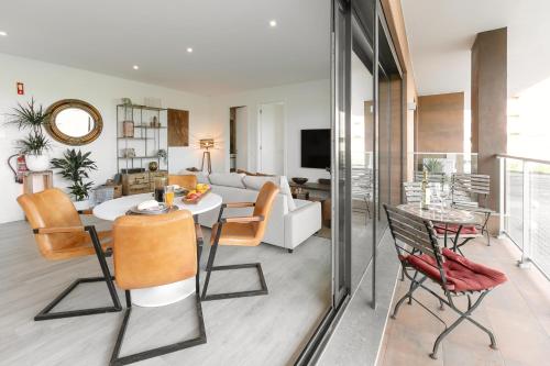a living room with a table and chairs and a couch at Casa Nascer do Sol in Atouguia da Baleia