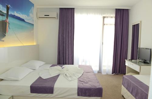 a hotel room with a bed with a bow on it at Diamond Kiten in Kiten