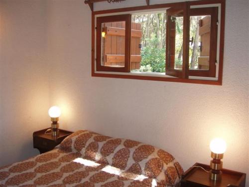 1 dormitorio con 1 cama y 2 luces en 2 mesas en Rincon del Bosque - Tritones 790 en Pinamar