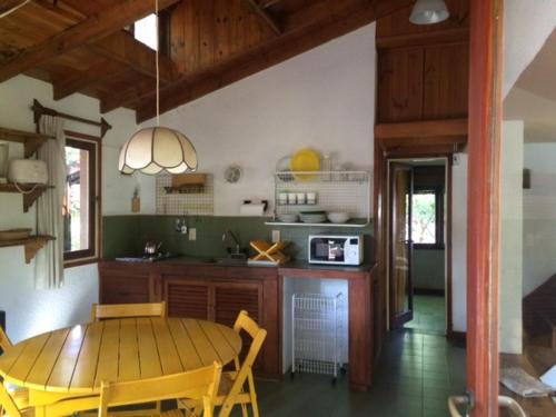 cocina con mesa de madera y comedor en Rincon del Bosque - Tritones 790 en Pinamar