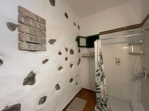 a bathroom with a rock wall with a shower at Bed&Ride La Manigua in Ojos de Garza