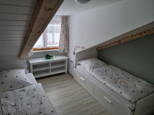 ein kleines Schlafzimmer mit 2 Betten und einem Fenster in der Unterkunft Haus Kuchler in Bayerisch Eisenstein