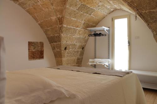 a bedroom with a bed with a stone wall at B&B Nino Moro in Casarano