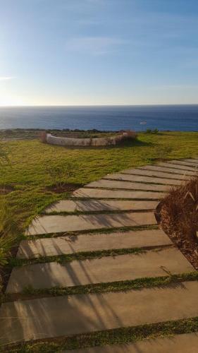 a stone walkway leading to the ocean on a beach at Marina Golf appartement de luxe in Asilah