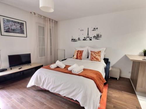 une chambre avec un grand lit avec deux serviettes dessus dans l'établissement Le cocon d'Ariane *Disney*Paris*Gare à 100m*, à Chessy