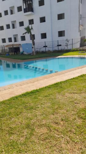 an empty swimming pool in front of a building at Marina Golf appartement de luxe in Asilah