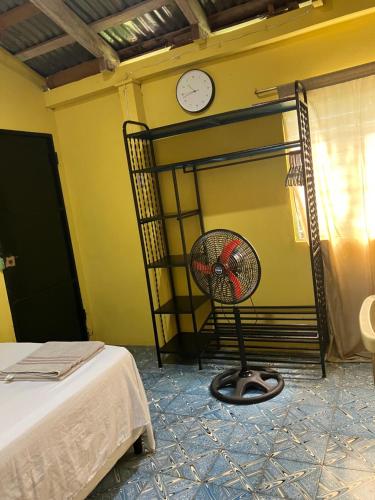 a room with a fan and a clock on the wall at Hostal El Amate #1 in Suchitoto