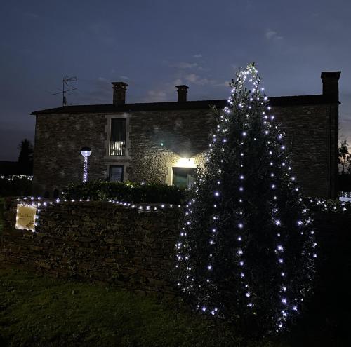 a christmas tree in front of a brick house at Casa Elvira in Marquiño