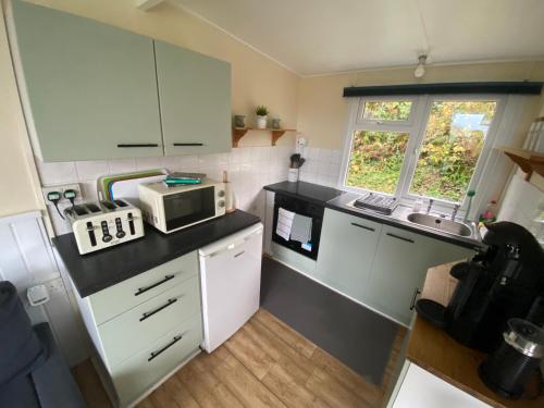 a small kitchen with a sink and a microwave at Bay view chalet, 28 Sea Valley in Bucks Mills