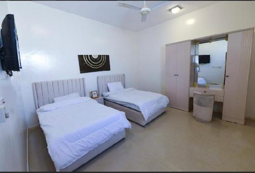 a hotel room with two beds and a television at استراحة الضبيانية in AlUla