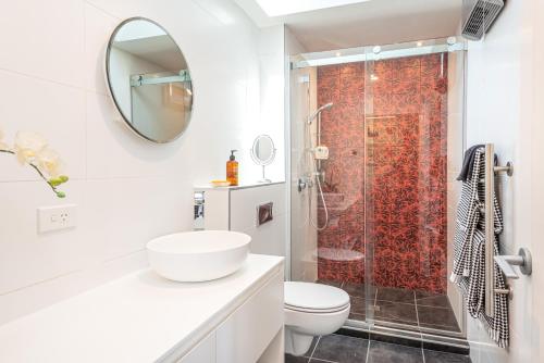 La salle de bains blanche est pourvue d'une douche et de toilettes. dans l'établissement Christchurch - Art space, sea views, private, à Christchurch