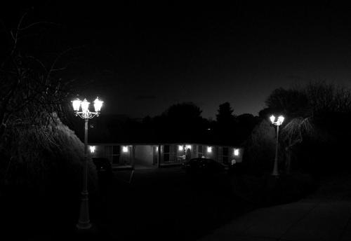 dos luces de la calle delante de una casa por la noche en White Lanterns Motel, en Armidale