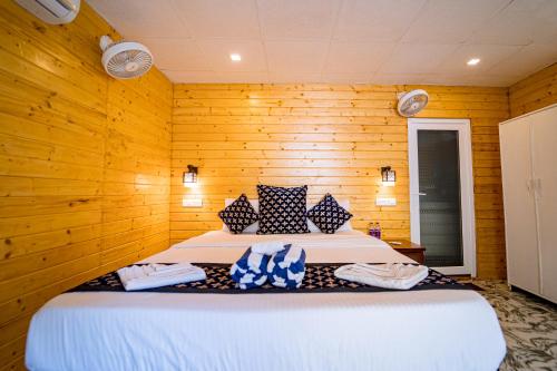 a bedroom with a bed in a wooden wall at orange sky beach bungalow in Agonda