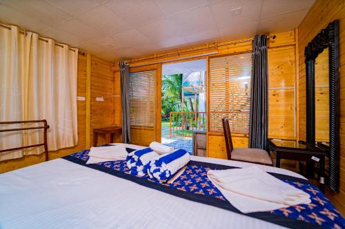 a bedroom with a bed and a window at orange sky beach bungalow in Agonda