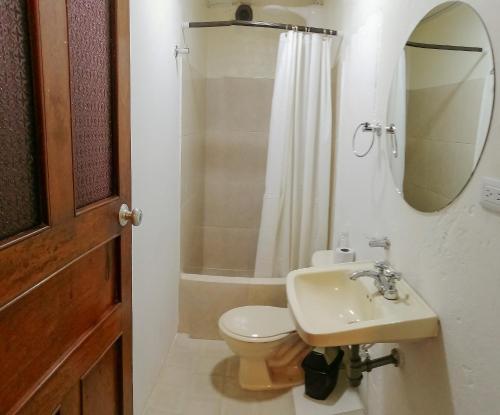 uma casa de banho com um WC, um lavatório e um espelho. em Aparta Estudios en la Plaza de Toros em Bogotá