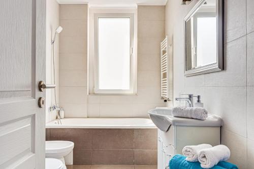 アラドにあるDodi Blue Apartamentの洗面台、浴槽、トイレを備えたバスルーム