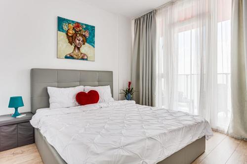 a bedroom with a white bed with a red heart on it at Dodi Blue Apartament in Arad