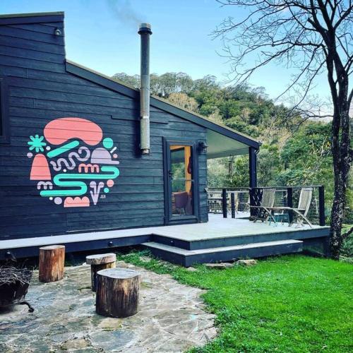 a house with a painting on the side of it at PencilWood Farm - Berry rainforest sanctuary in Woodhill