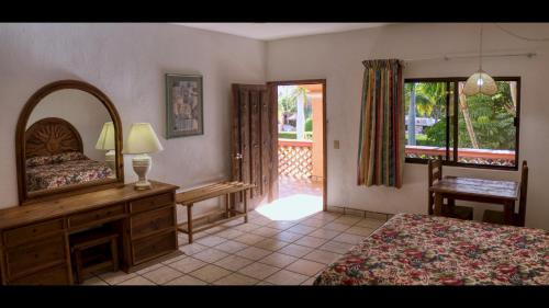 a bedroom with a bed and a dresser and a mirror at Los Barriles Hotel in Los Barriles