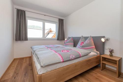 a bedroom with a large bed with a window at Appartement Tannenhof III in Ramsau am Dachstein