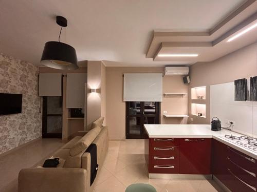 Alloggio Olimpico PalaAlpitour في تورينو: مطبخ وغرفة معيشة مع أريكة وطاولة