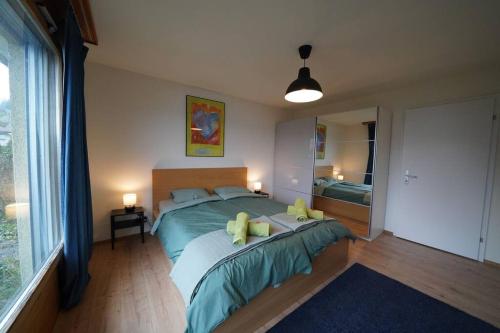 1 dormitorio con 1 cama con sábanas verdes y almohadas amarillas en Sonniges Haus bei Bern, en Herrenschwanden