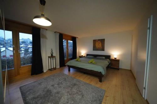 a bedroom with a bed and a large window at Sonniges Haus bei Bern in Herrenschwanden